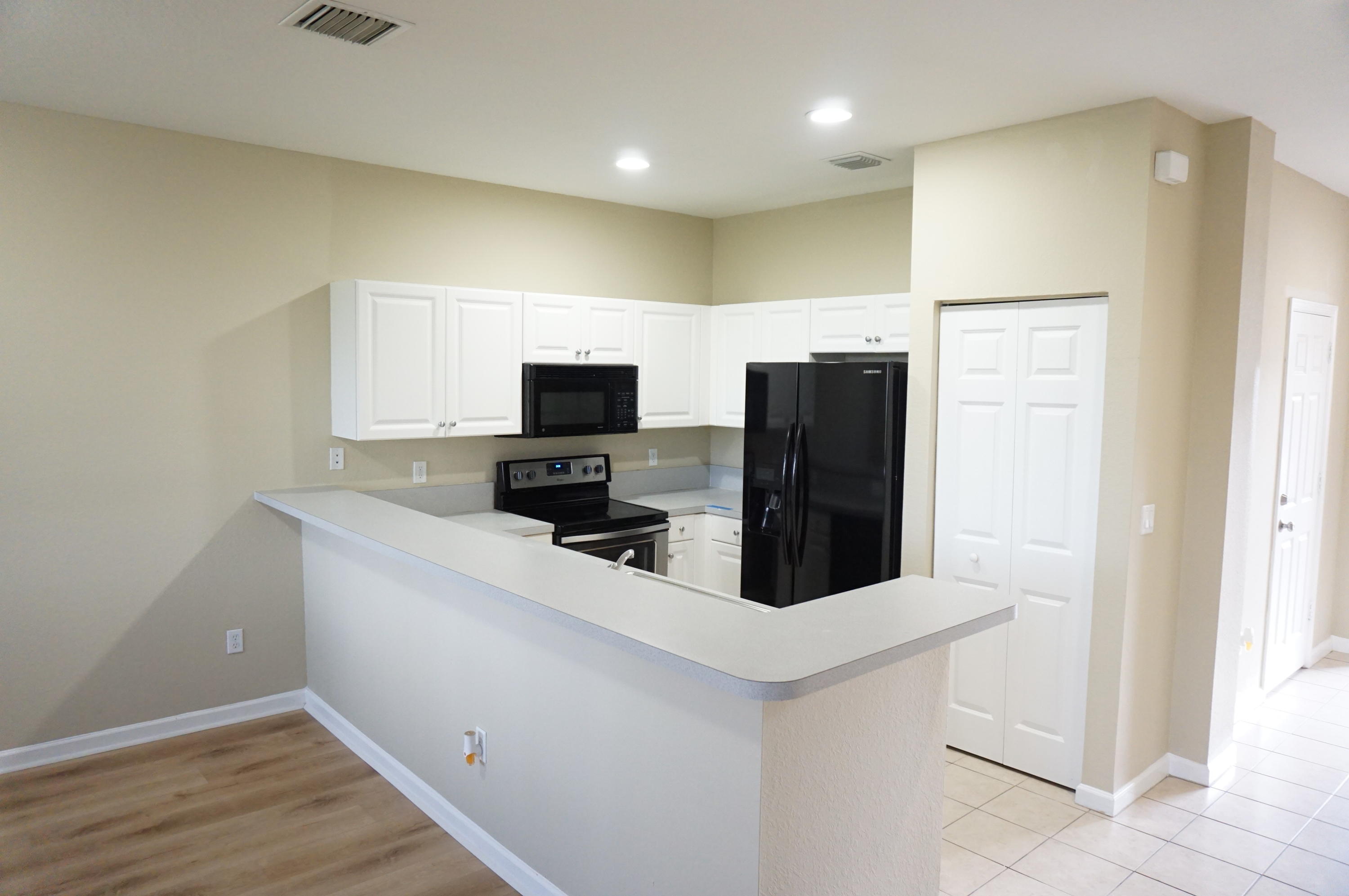 a kitchen with a sink a microwave a refrigerator and cabinets