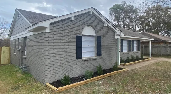 a view of house with backyard and glass windows