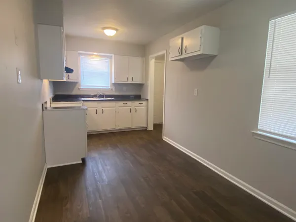 a kitchen with cabinets and wooden floor