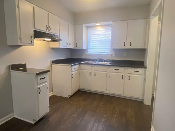 a kitchen with white cabinets stainless steel appliances and sink