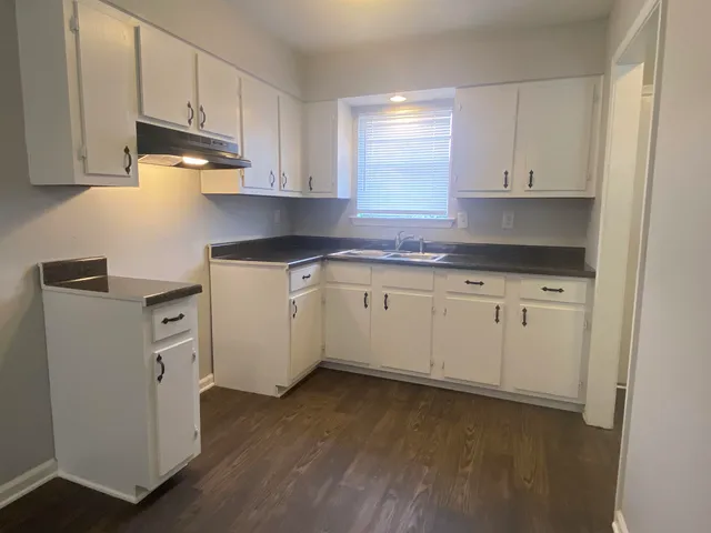a kitchen with white cabinets stainless steel appliances and sink