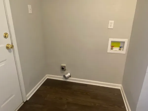 a view of a small space with wooden floor and a window