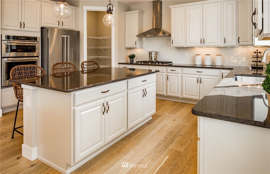 115 215th Street Southeast, Unit 6 Bothell, WA 98021 - Photo 10 of 18 a kitchen with stainless steel appliances kitchen island granite countertop a sink and cabinets