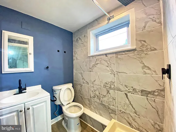 a bathroom with a toilet sink vanity and mirror