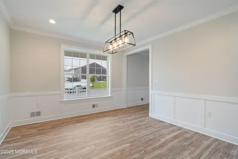 a large kitchen with kitchen island white cabinets and wooden floor