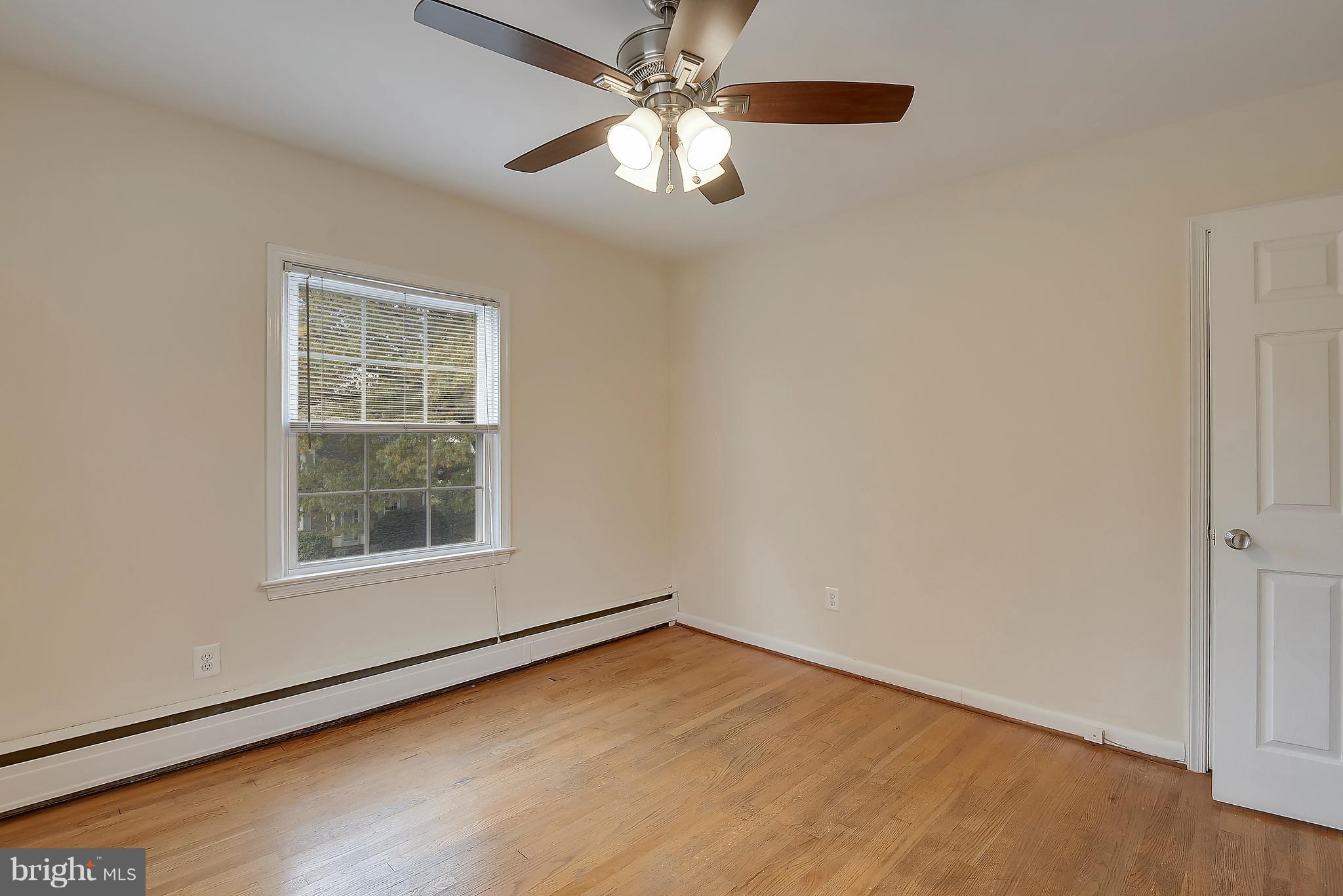 4023 18th Road North, Unit 1 Arlington, VA 22207 - Photo 11 of 30 an empty room with wooden floor chandelier fan and windows
