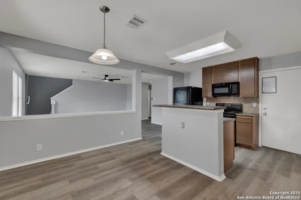 a kitchen with stainless steel appliances granite countertop a refrigerator a stove top oven a sink dishwasher and wooden floor