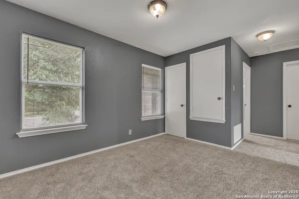 an empty room with windows and closet