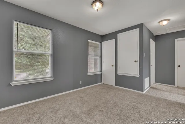 an empty room with windows and closet