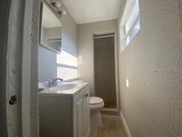 907 Columbia Street Orlando, FL 32805 - Photo 15 of 30 a bathroom with a granite countertop sink a toilet and a mirror