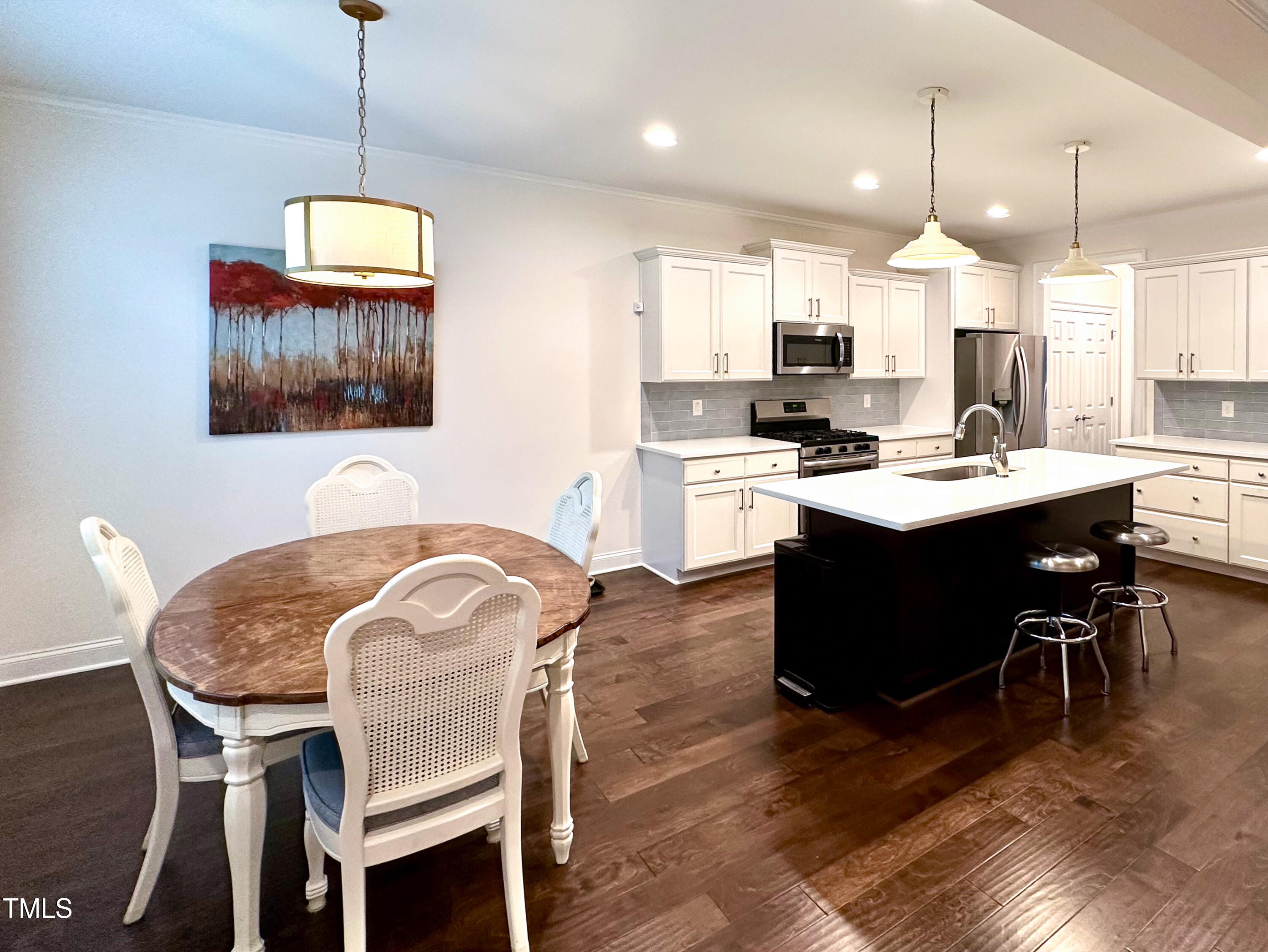 409 Eagle Court Henderson, NC 27536 - Photo 3 of 54 a kitchen with a dining table chairs and white cabinets