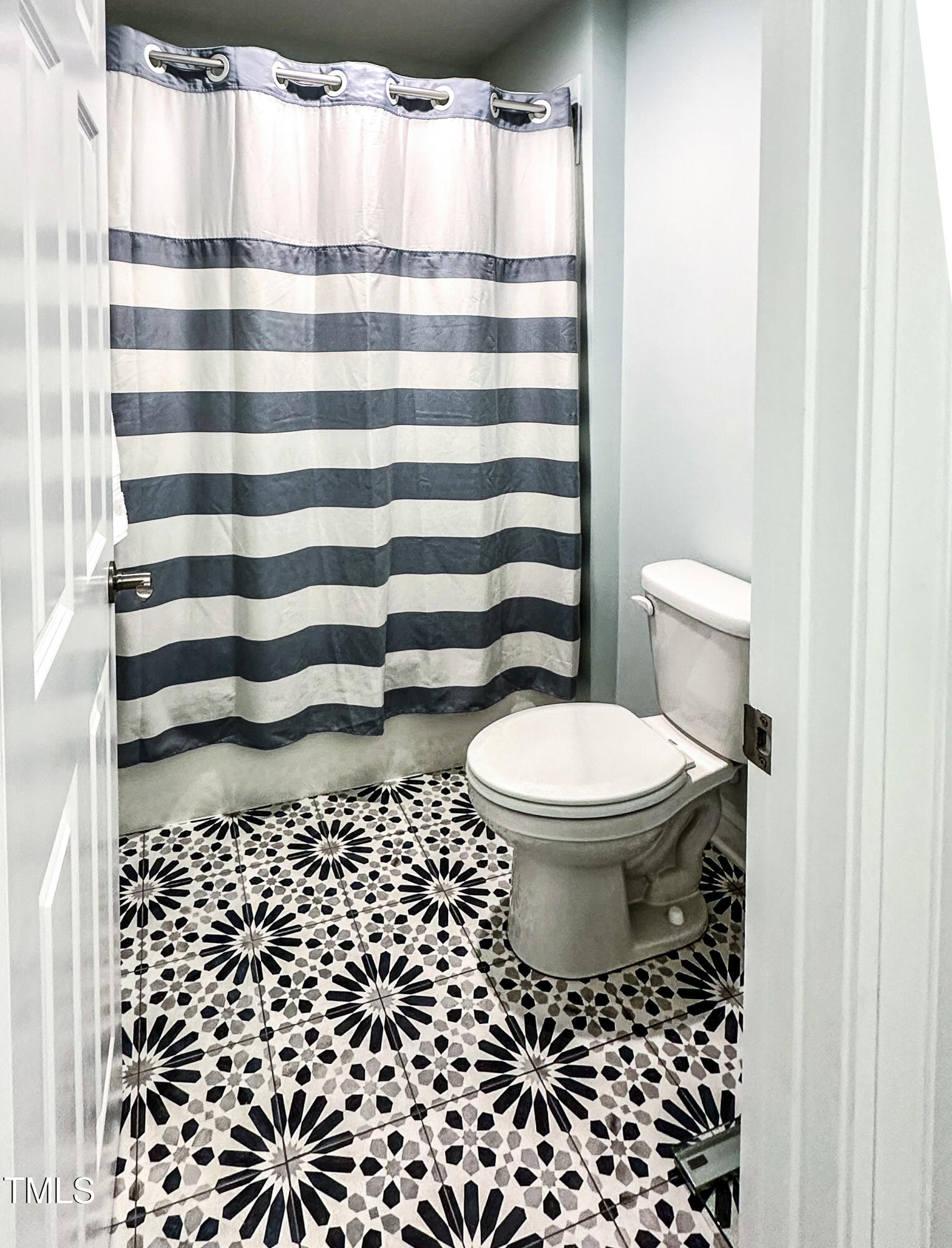 409 Eagle Court Henderson, NC 27536 - Photo 35 of 54 a bathroom with a toilet and a shower curtain