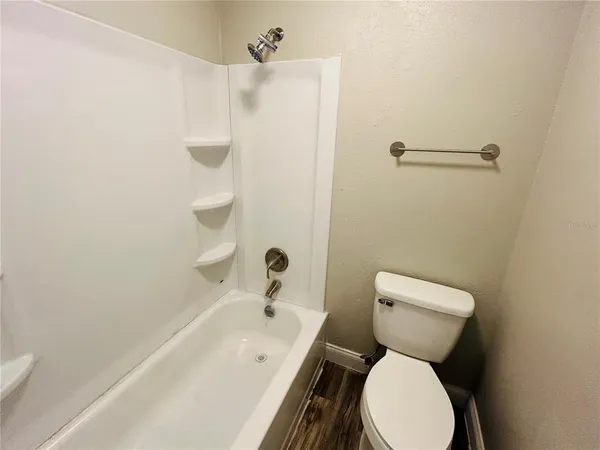 a white toilet sitting next to a bath tub