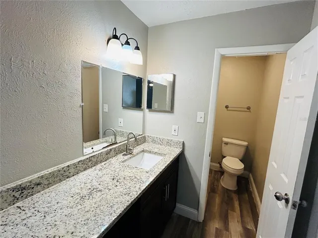 a bathroom with a granite countertop sink and a mirror