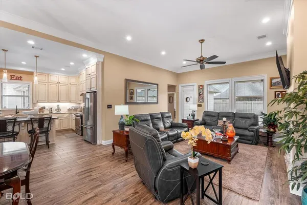 a living room with furniture kitchen view and a large window