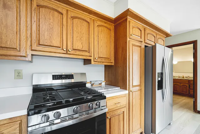 a kitchen with stainless steel appliances granite countertop a refrigerator and a stove