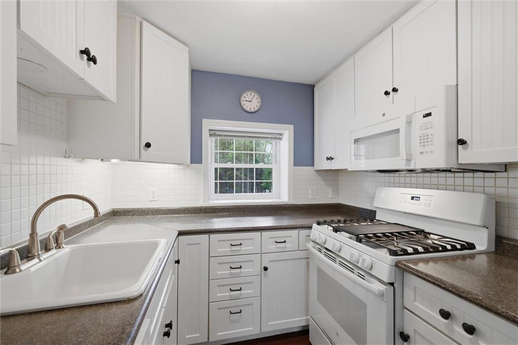 7092 Mercer Road Polk, PA 16342 - Photo 18 of 50 a kitchen with cabinets appliances a sink and a window