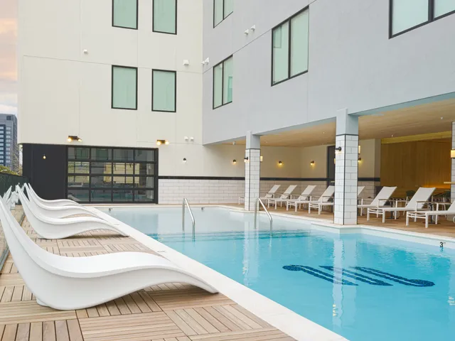a kitchen with a sink dishwasher a stove and white cabinets with wooden floor
