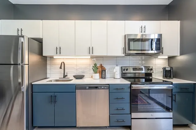 a kitchen with stainless steel appliances granite countertop a sink and dishwasher a stove top oven with wooden floor