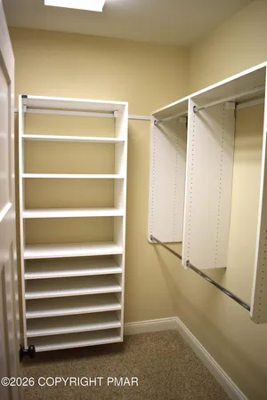 a view of walk in closet with empty racks