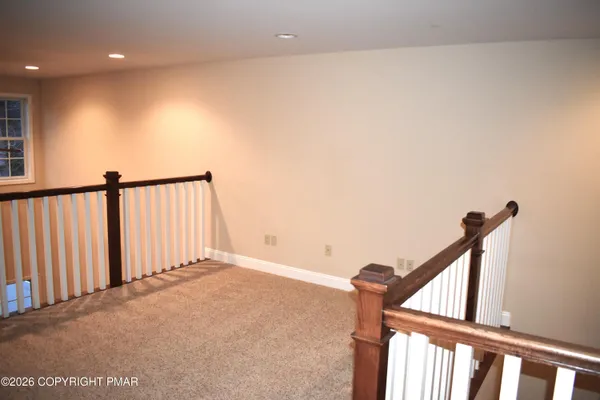 a view of staircase with railing and white walls
