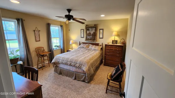 a spacious bedroom with a bed and a dresser in it