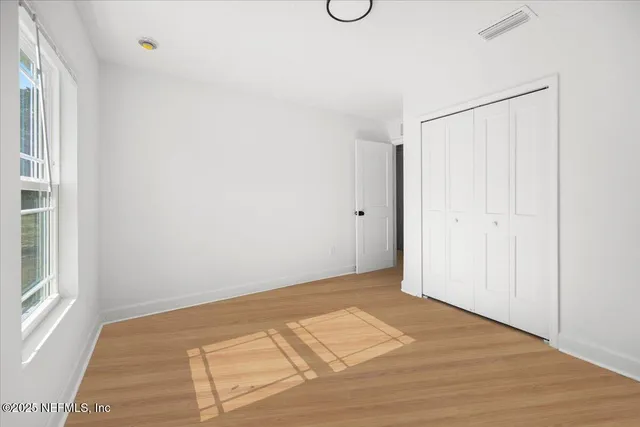 a view of a room with wooden floor and windows