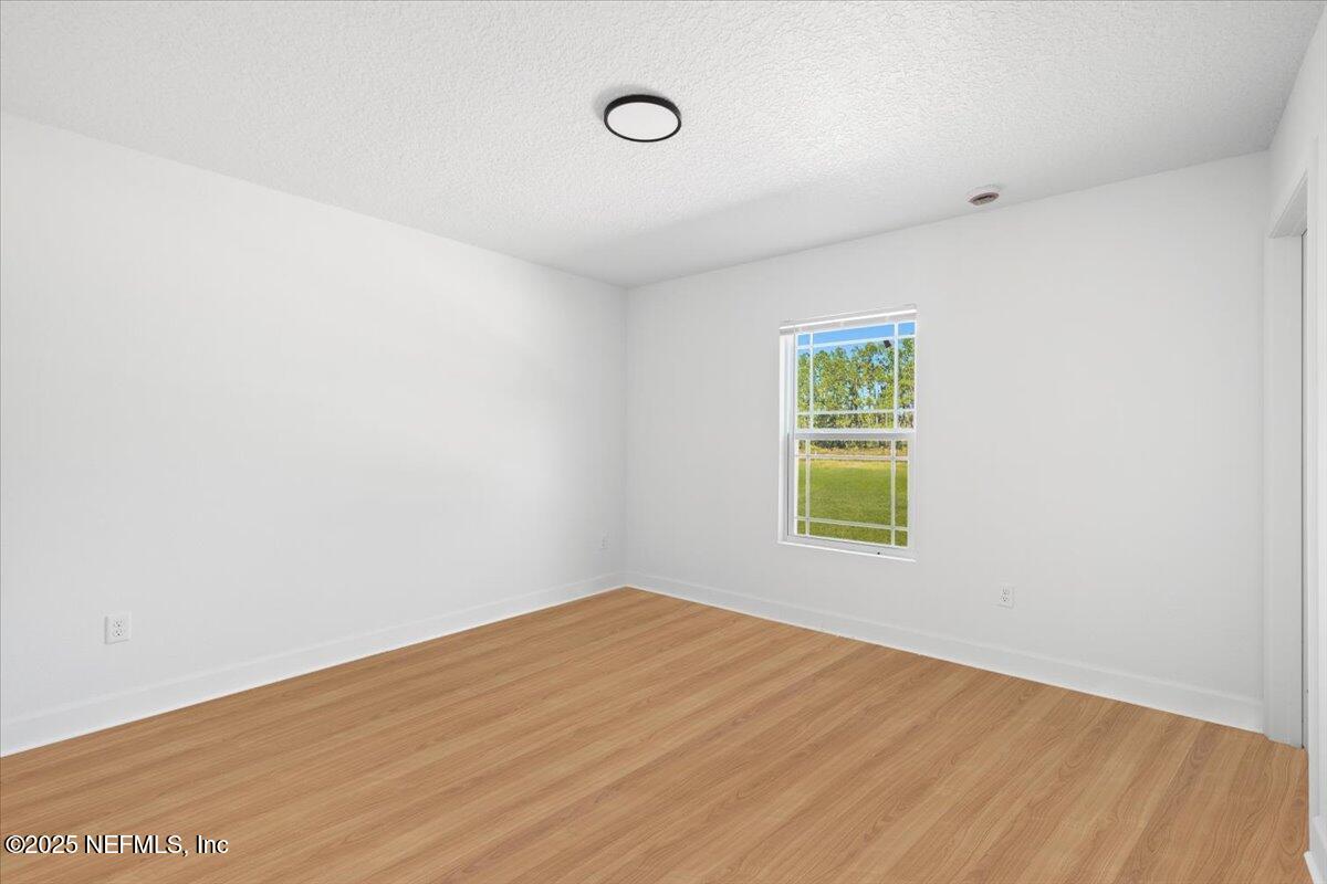 5432 Laredo Street Keystone Heights, FL 32656 - Photo 16 of 23 a view of an empty room with wooden floor and a window