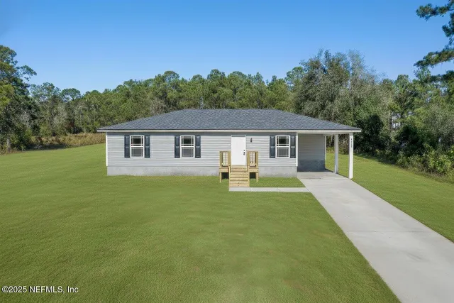 a front view of a house with yard patio and green space