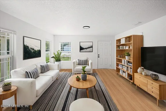 a living room with furniture flat screen tv and wooden floor