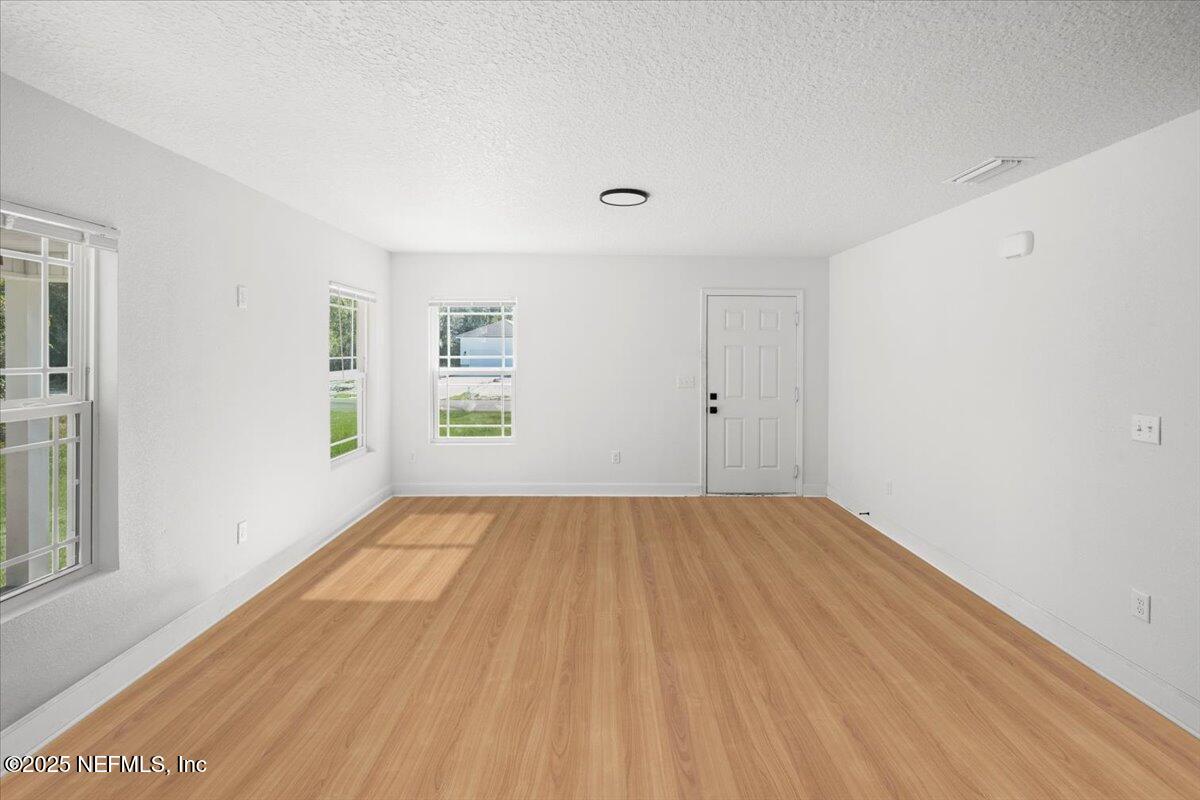 5432 Laredo Street Keystone Heights, FL 32656 - Photo 5 of 23 wooden floor in an empty room with a window