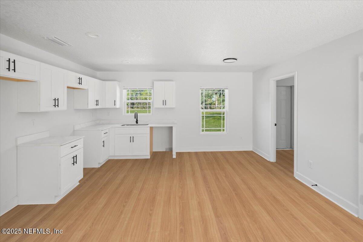 5432 Laredo Street Keystone Heights, FL 32656 - Photo 7 of 23 a view of a kitchen with wooden floor and a sink