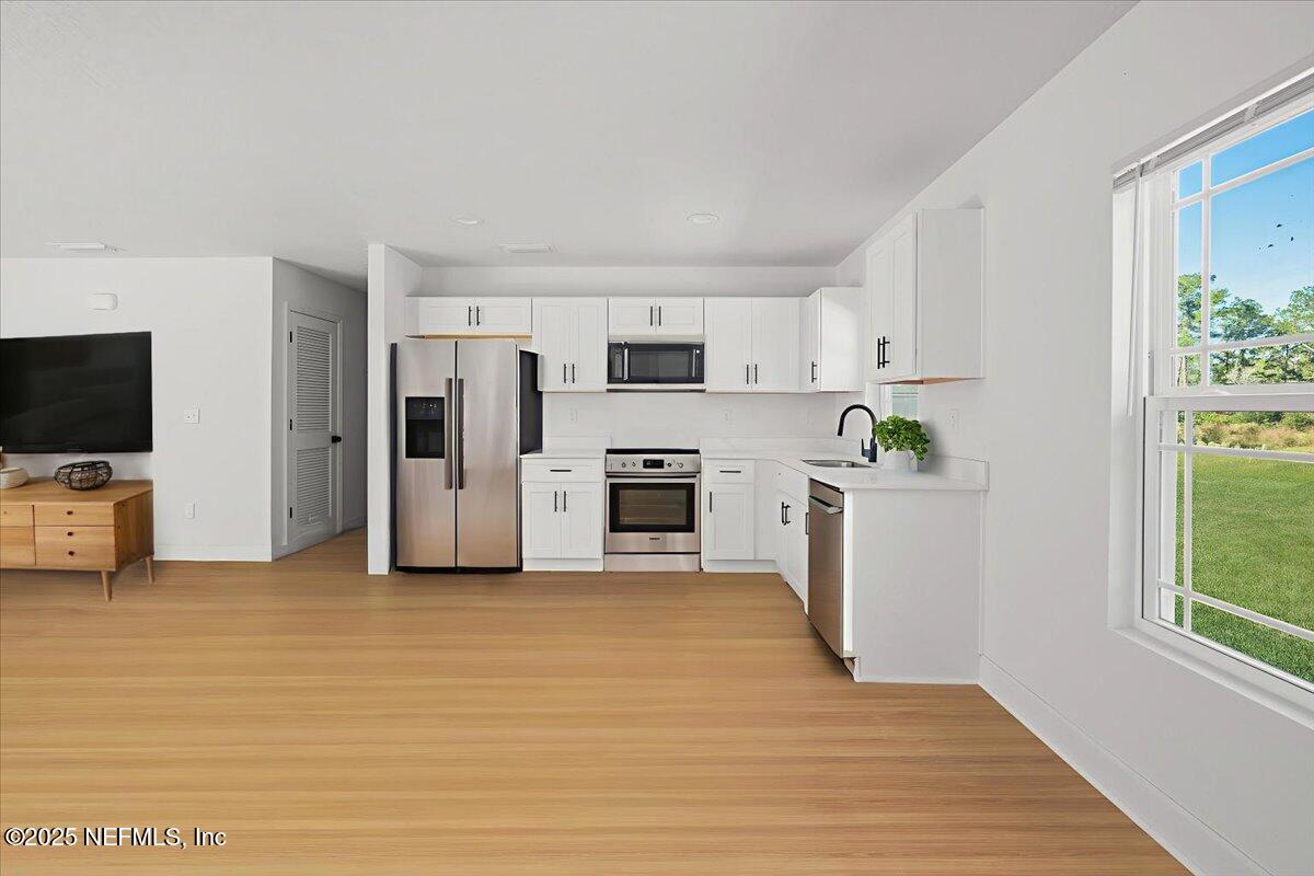 5432 Laredo Street Keystone Heights, FL 32656 - Photo 9 of 23 a view of a kitchen with refrigerator stove and wooden floor