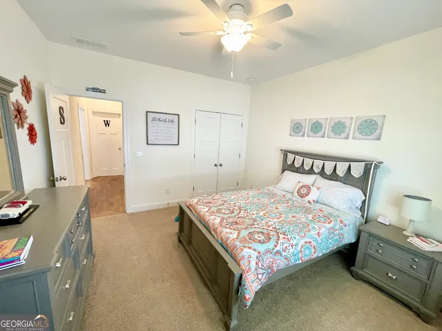 a bedroom with a bed and a flat tv screen on the dresser