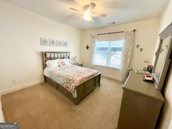 a bedroom with a bed and a flat tv screen on the dresser