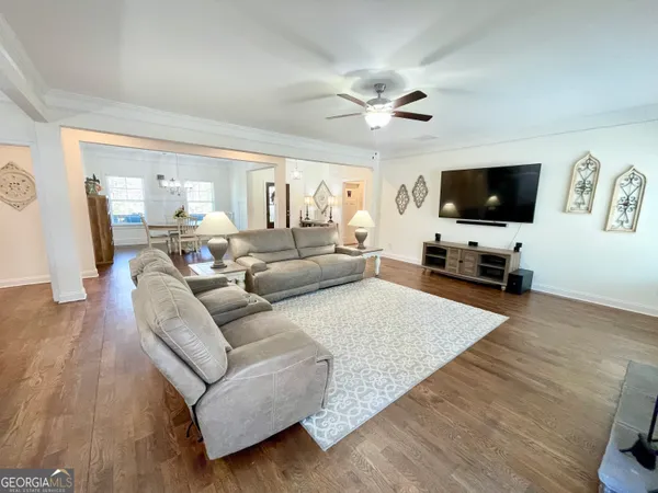 a kitchen with stainless steel appliances granite countertop a kitchen island a stove a refrigerator a sink dishwasher a dining table and chairs with wooden floor