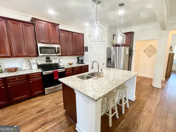 a kitchen with stainless steel appliances granite countertop wooden cabinets a stove top oven a sink and dishwasher