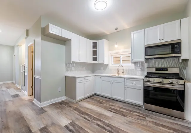 a kitchen with granite countertop a stove a sink and a refrigerator