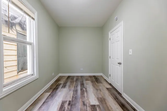 a view of a room with wooden floor and window