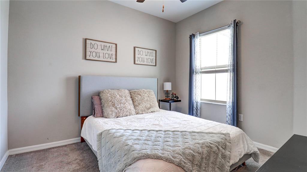 31632 Blue Passing Loop Wesley Chapel, FL 33545 - Photo 34 of 48 a large bed in a bedroom next to a window