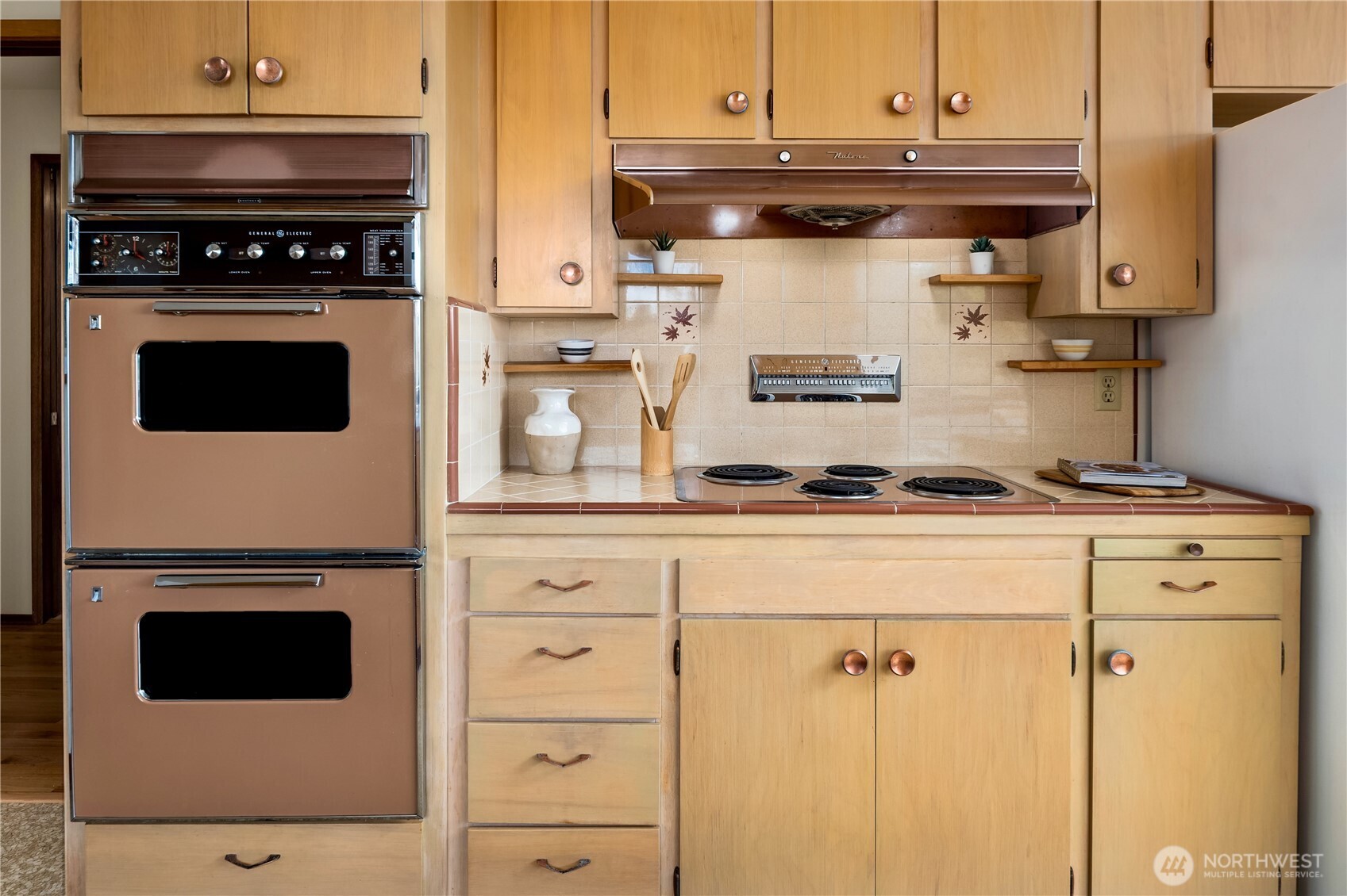 4241 Southwest Donovan Street Seattle, WA 98136 - Photo 14 of 40 a stove top oven sitting inside of a kitchen and white cabinets