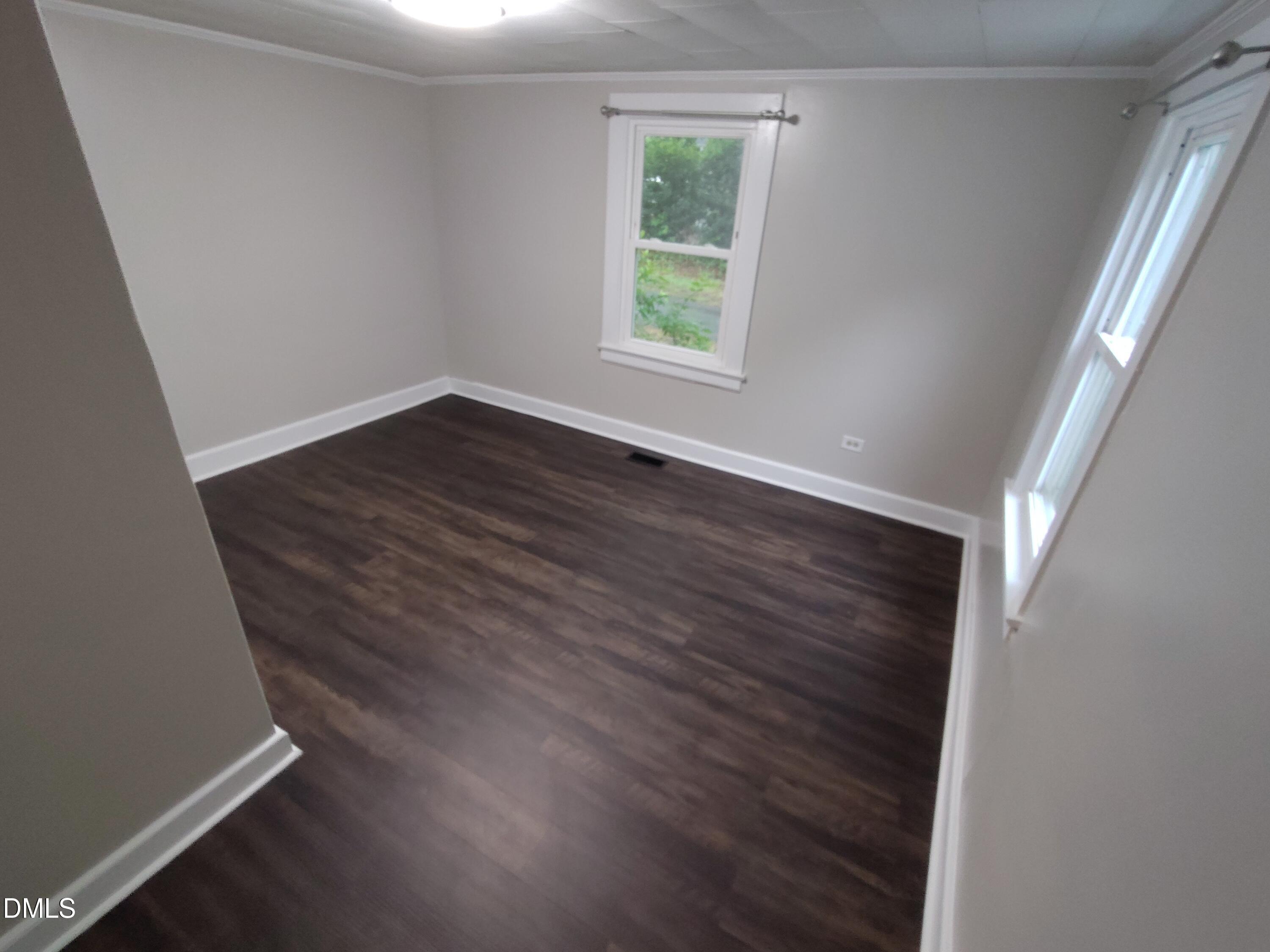 808 Glenco Road Durham, NC 27703 - Photo 13 of 17 an empty room with wooden floor and windows
