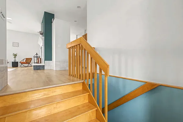 a view of staircase with white walls and railing next to a window