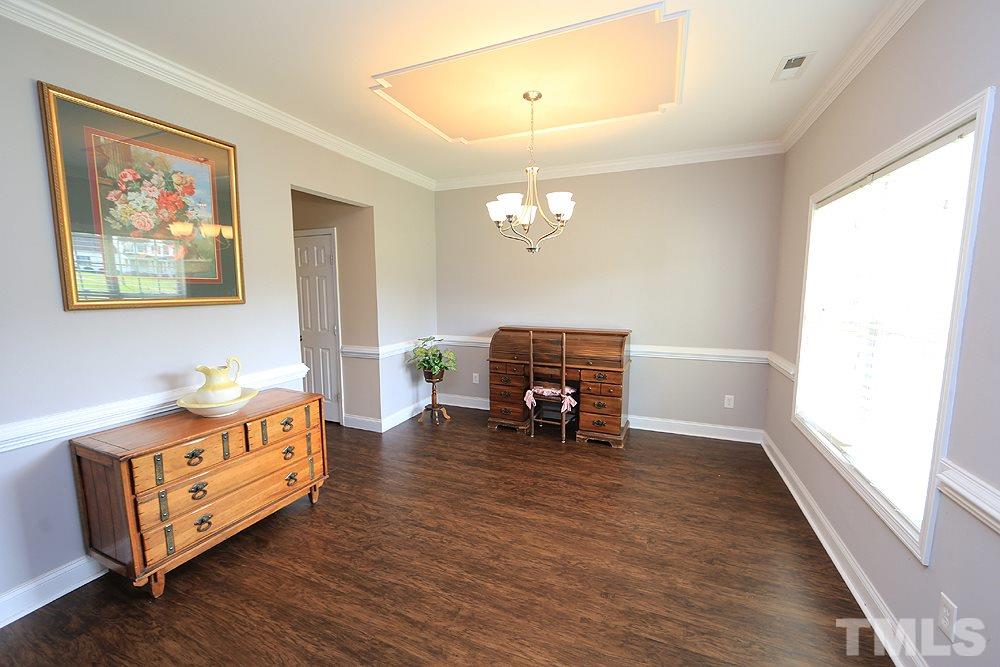 4609 Pearl Road Raleigh, NC 27610 - Photo 2 of 12 a living room with furniture and a dining table with wooden floor