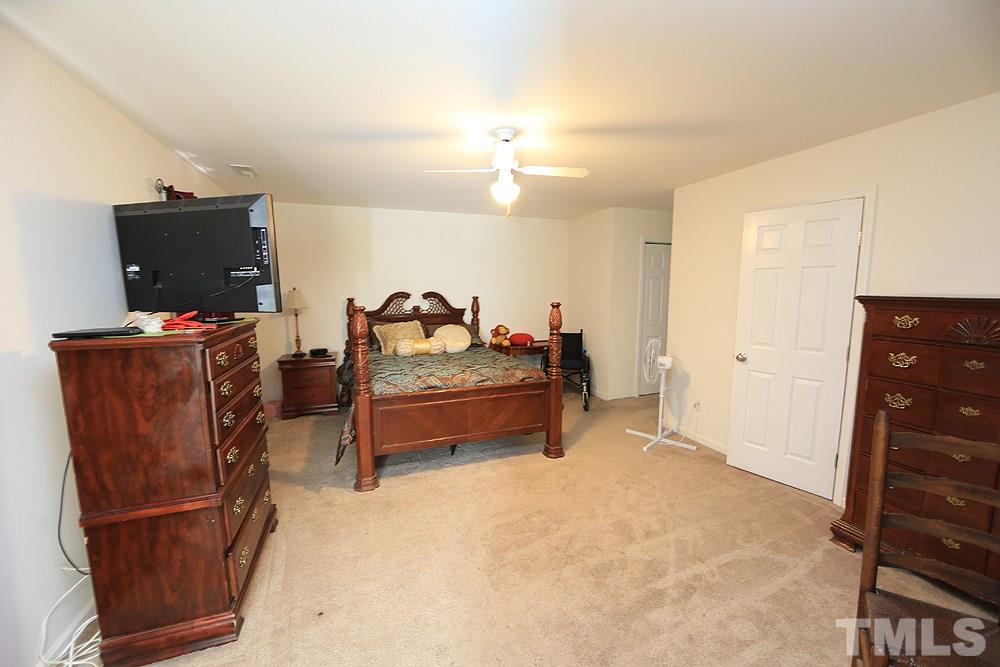4609 Pearl Road Raleigh, NC 27610 - Photo 6 of 12 a bedroom with furniture and a flat screen tv