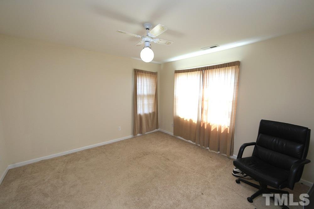 4609 Pearl Road Raleigh, NC 27610 - Photo 8 of 12 an empty room with windows and ceiling fan
