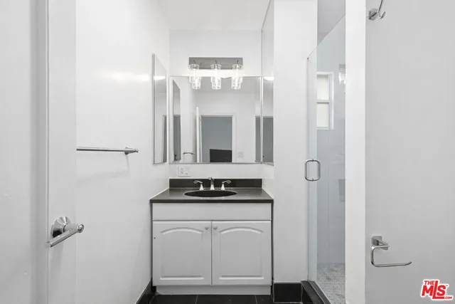 a bathroom with a shower a sink and a mirror