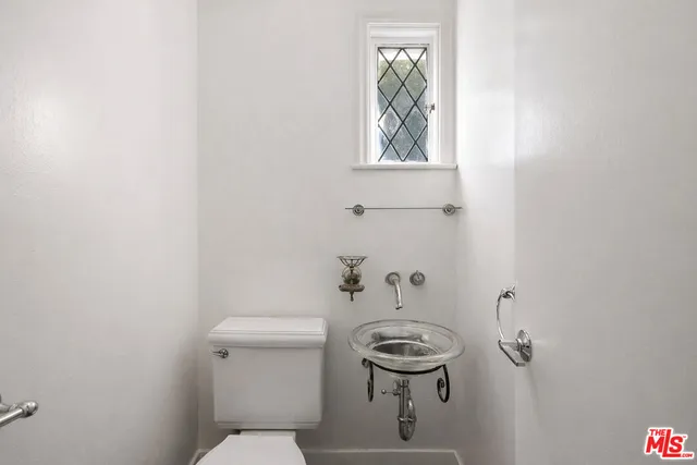 a bathroom with a sink toilet a mirror and shower