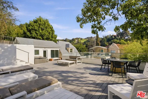 a view of a patio with couches table and chairs and potted plants