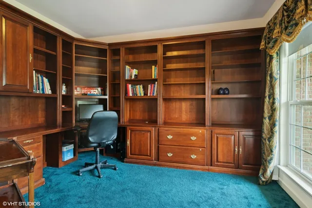a view of a workspace with furniture and a bookshelf